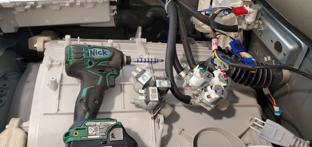 Drill and replacement valves on an opened washing machine