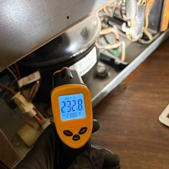 Infrared thermometer checking a hot appliance component