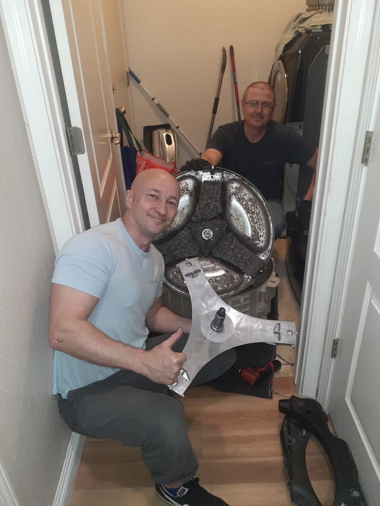 Niko and Alex working together on a washing machine repair